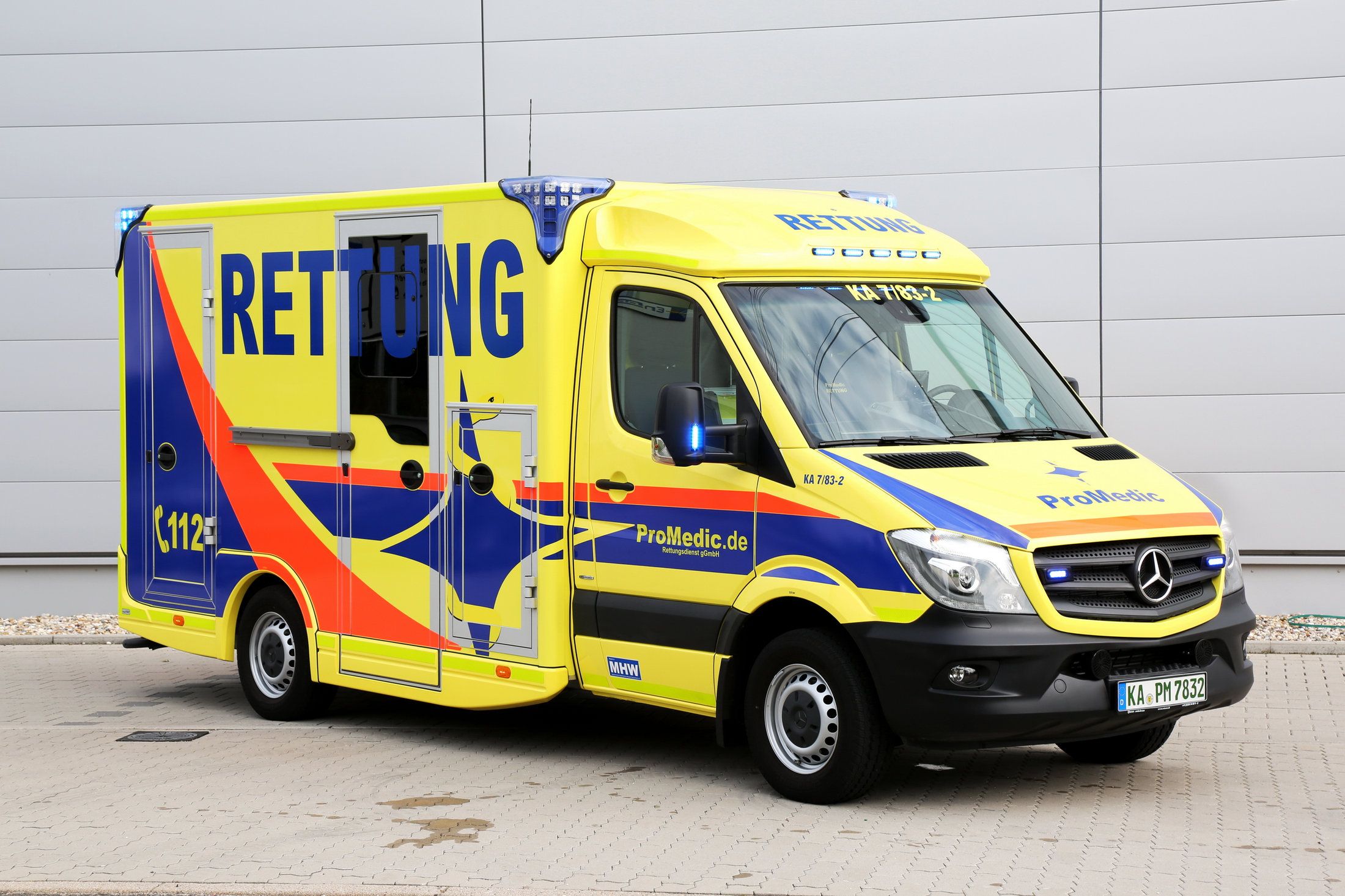 Gelb-blauer ProMedic-Rettungswagen vor der Fahrzeughalle