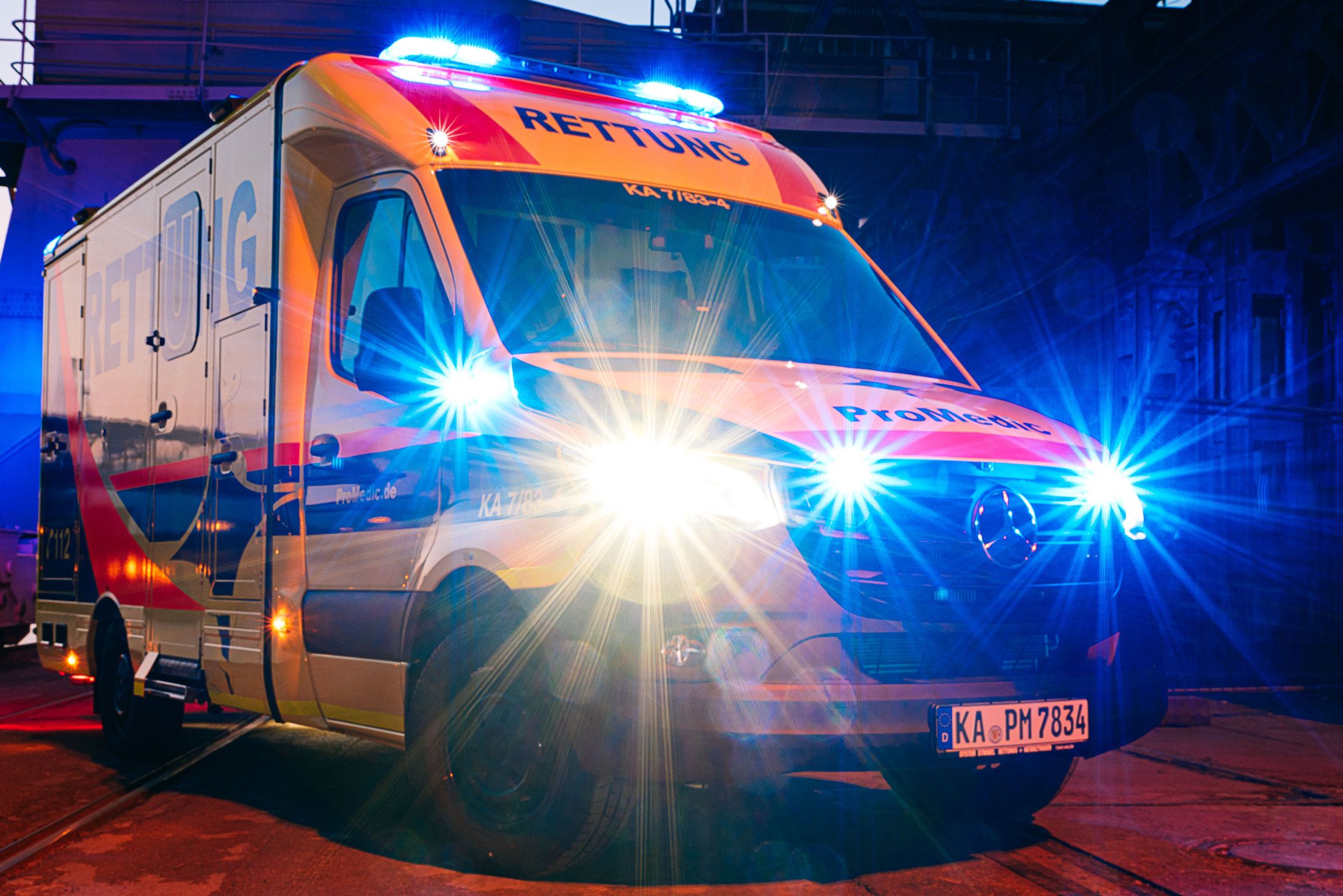 ProMedic-Rettungswagen bei Nacht mit Blaulicht und Frontblitzern